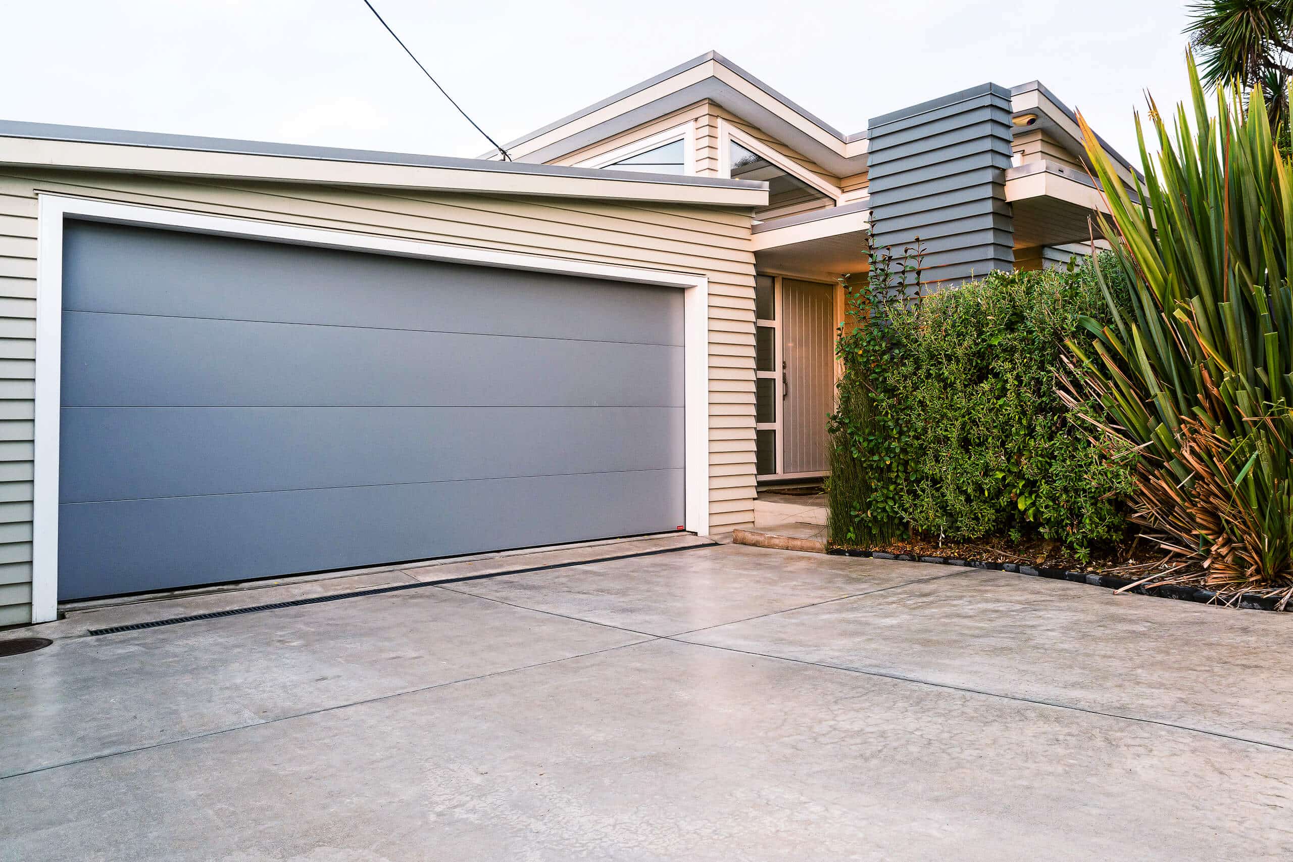 coloured-concrete-driveway-paths Coloured concrete driveway with contrasting grout.
